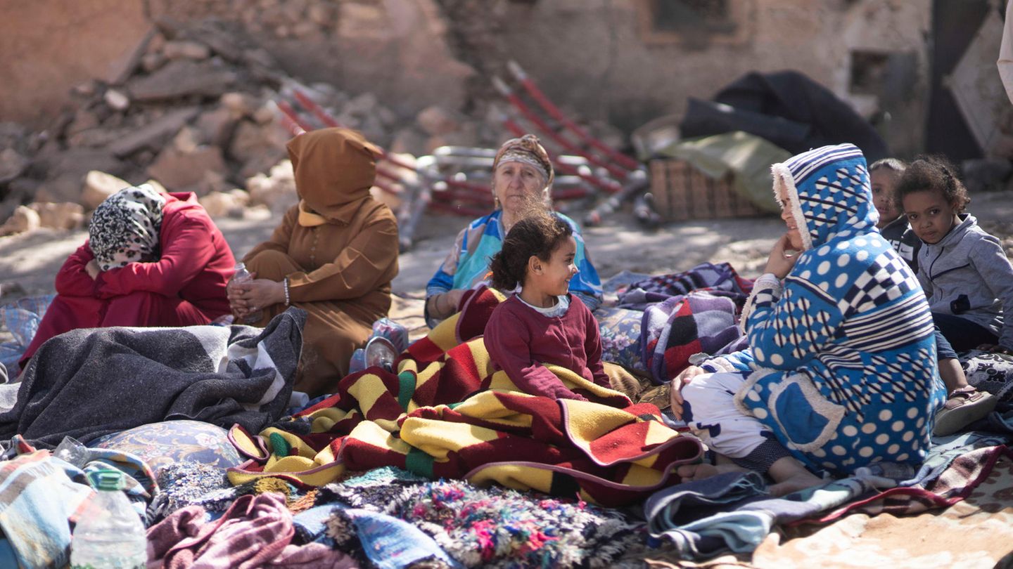 Familien sitzen vor ihren zerstörten Häusern, ebenfalls in Marrakesch. Sie haben alles verloren.