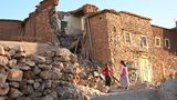 Kinder stehen vor einem beschädigten Gebäude in Tahannaout bei Marrakesch. Vor allem nahe des Epizentrums im Atlasgebirge sind ganze Dörfer zerstört