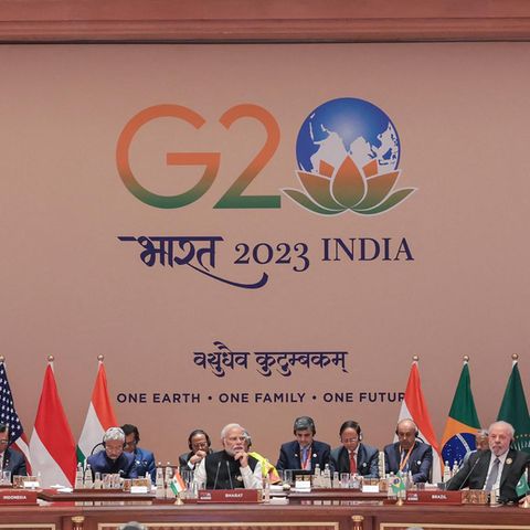 Die Mächtigen der Welt sitzen beim G20 Gipfel in Indien auf einem Podium nebeneinander