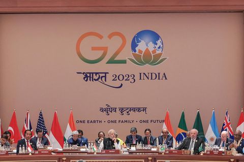 Die Mächtigen der Welt sitzen beim G20 Gipfel in Indien auf einem Podium nebeneinander