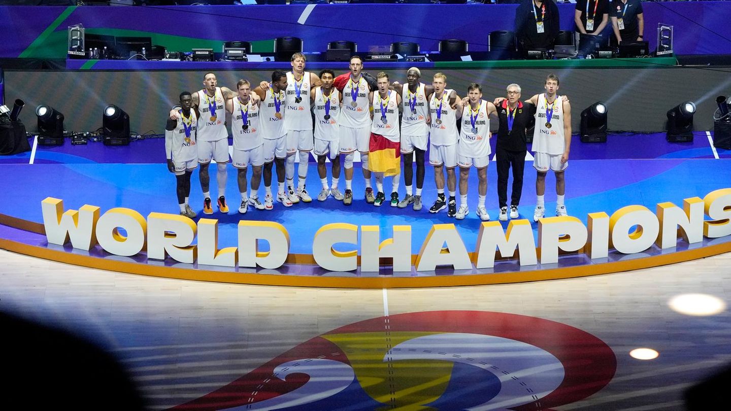 Arm in Arm singen die deutschen Baskteball-Weltmeister bei der Siegerehrung die Nationalhymne