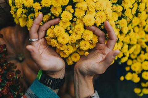 Eine Frau gießt Blumen im Garten.