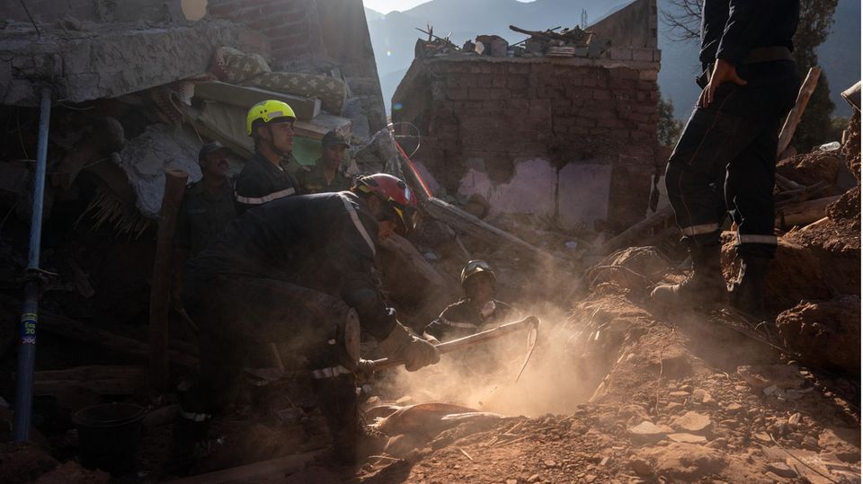 Rettungskräfte in Marokko tragen behutsam Erde und Gestein ab