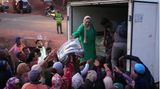 Helfer verteilen Decken bei den Menschen, die durch das Erdbeben obdachlos geworden sind