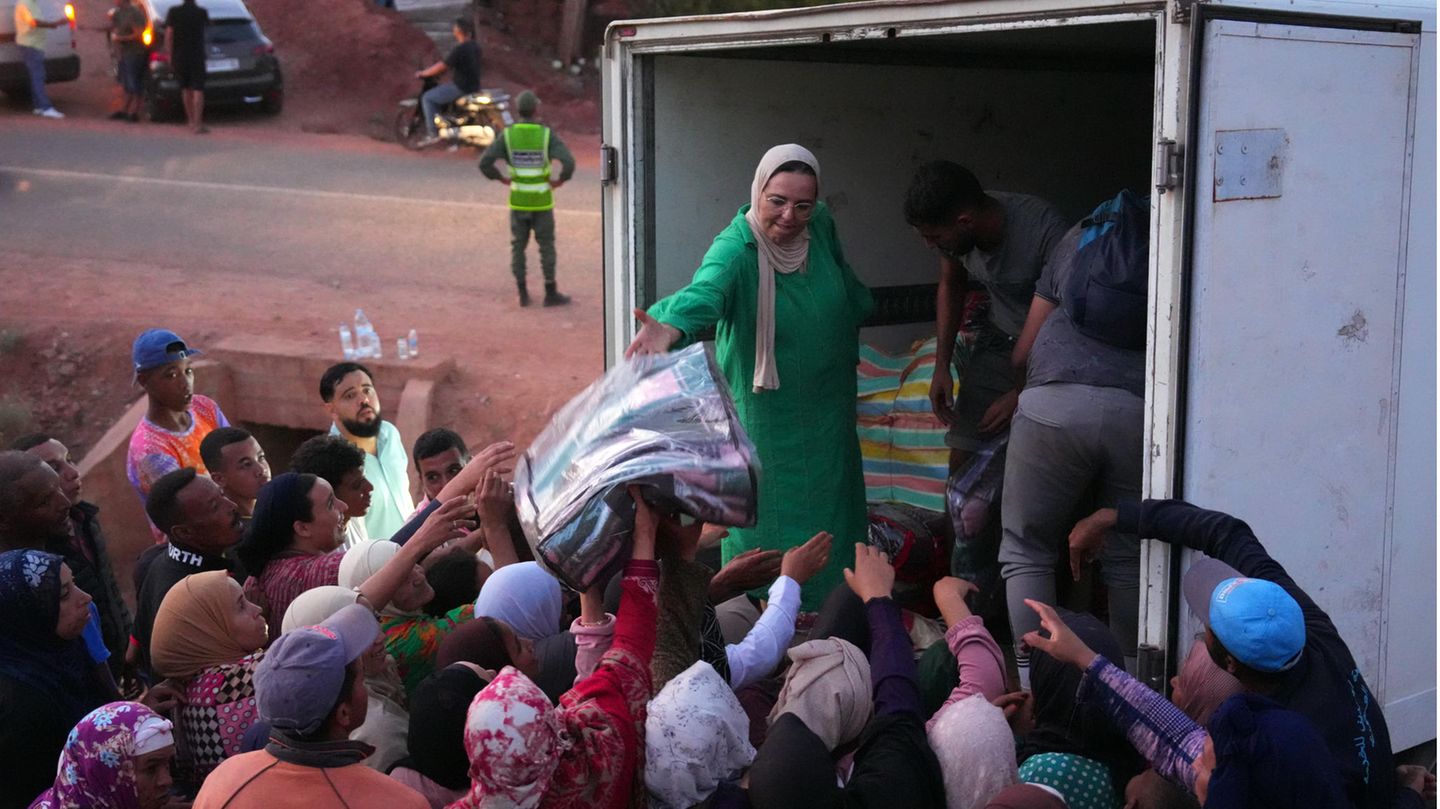 Helfer verteilen Decken bei den Menschen, die durch das Erdbeben obdachlos geworden sind