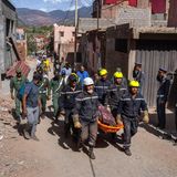 Rettungskräfte tragen eine Trage durch das Dorf