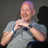 Matthias Sammer sitzt und lacht bei einer Pressekonferenz