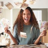 Eine Frau wirft vor Glück Geld in die Luft