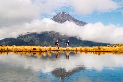 Zwei Wanderer vor dem Mount Taranaki in Neuseeland