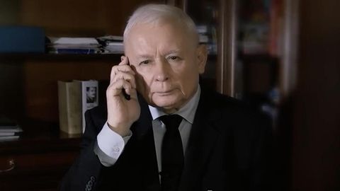 Der polnische Politiker Jarosław Kaczyński in schwarzem Anzug mit Telefon am Ohr