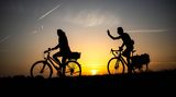 Bremen, Deutschland. Morgenstund' hat Gold im Mund, dachten sich wohl diese beiden Radfahrer und wurden belohnt – mit einem strahlenden Sonnenaufgang über der Weser.