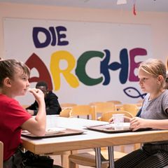 Zwei Mädchen sitzen an einem Tisch