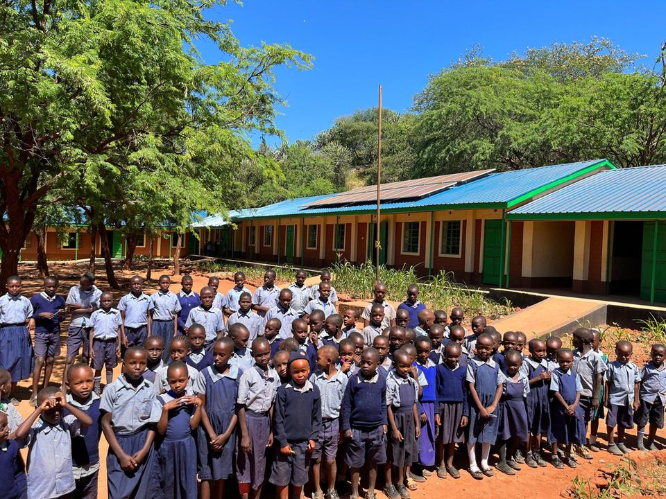 Viele junge Kinder stehen vor einer Schule in Kenia Viele junge Kinder stehen vor einer Schule in Kenia