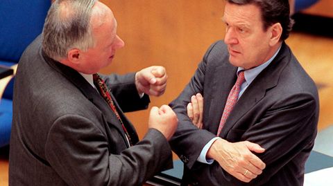 Gestenreich unterhalten sich der SPD-Vorsitzende und Bundesfinanzminister Oskar Lafontaine (l) und Bundeskanzler Gerhard Schröder am 23.2.1999 vor Beginn der Haushaltsdebatte im Bonner Bundestag