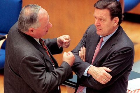 Gestenreich unterhalten sich der SPD-Vorsitzende und Bundesfinanzminister Oskar Lafontaine (l) und Bundeskanzler Gerhard Schröder am 23.2.1999 vor Beginn der Haushaltsdebatte im Bonner Bundestag