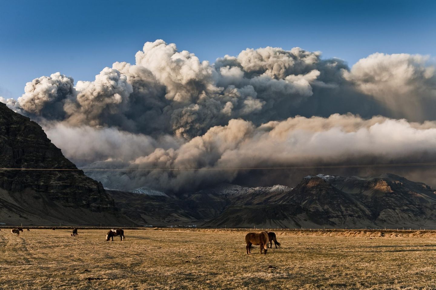 Eine riesige Aschewolke verdunkelt den Himmel über Islands weiter Landschaft