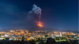 Der Ätna auf Sizilien spuckt Feuer in den Nachthimmel über der Stadt Pedara