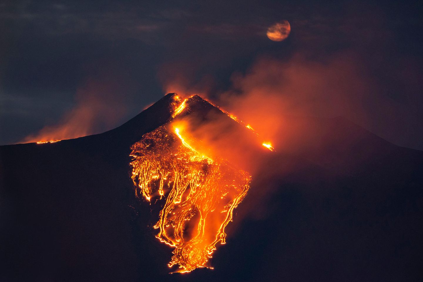 Lava fließt nachts aus dem Ätna die Südseite des Vulkans hinab
