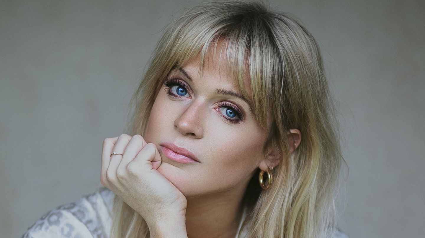 Dolly Alderton, eine junge Frau mit großen Augen und langen Haaren, stützt den Kopf auf ihrer Hand ab