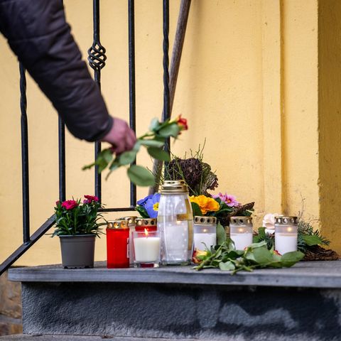 Jemand legt eine Rose am Tatort