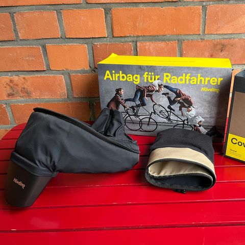Hövding 3 mit Zubehör auf einem roten Tisch