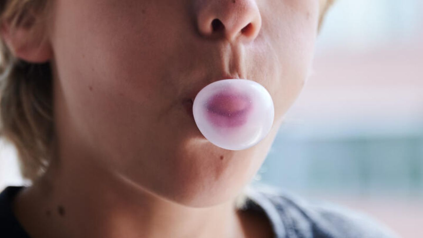 Ein Kind formt mit dem Mund eine Kaugummiblase. (gestellte Szene)