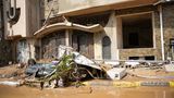 Ein zerstörtes Auto liegt vor einem Gebäude in Derna, Libyen