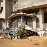 Ein zerstörtes Auto liegt vor einem Gebäude in Derna, Libyen