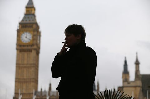 Eine Frau raucht eine Zigarette, hinter ihr ist der Big Ben zu sehen