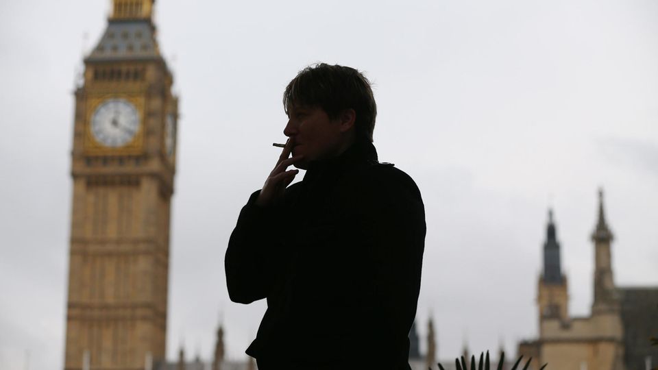 Eine Frau raucht eine Zigarette, hinter ihr ist der Big Ben zu sehen
