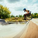 Ein Rollstuhlfahrer steht an einer Halfpipe