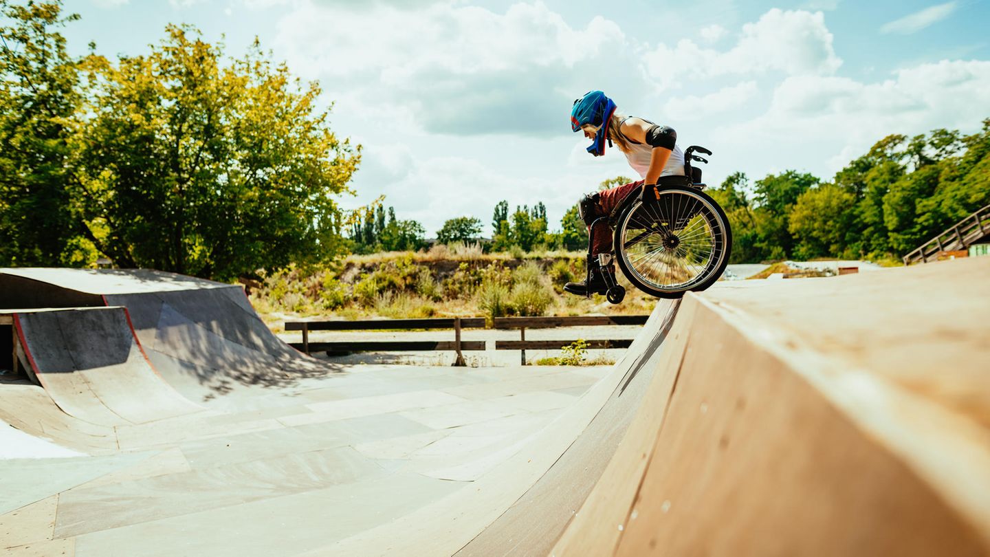 Ein Rollstuhlfahrer steht an einer Halfpipe