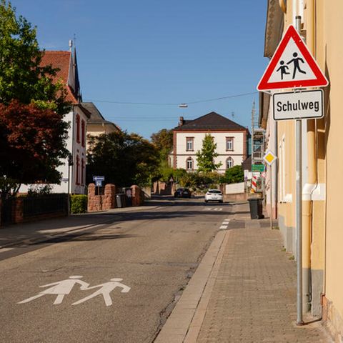 Ein Warnschild und ein Schild mit der Aufschrift Schulweg stehen am Rand der Luitpoldstraße in Edenkoben.