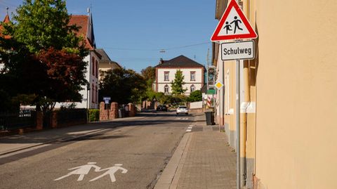 Ein Warnschild und ein Schild mit der Aufschrift Schulweg stehen am Rand der Luitpoldstraße in Edenkoben.