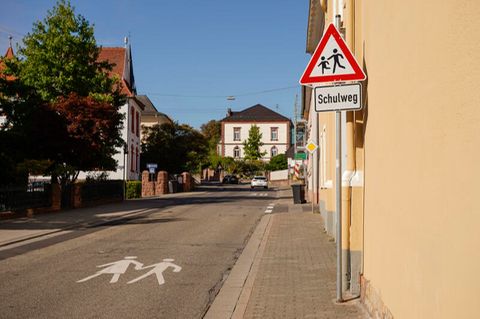 Ein Warnschild und ein Schild mit der Aufschrift Schulweg stehen am Rand der Luitpoldstraße in Edenkoben.