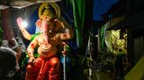 Kalkutta, Indien. Eine Statue der hinduistischen Elefantengottheit Ganesha wird im Dunken angeleuchtet. Demnächst beginnt in Indien das Ganesh Chaturthi-Fest zu Ehren der Göttin der Weisheit, des Glücks und des Erfolges. Monate im Voraus werden Figuren der Göttin hergestellt und überall aufgestellt. Zum Fest werden sie mit Blumen geschmückt.