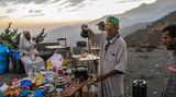 Al-Haouz, Marokko. Ein Mann gießt Tee aus einer Kanne in eine Tasse. Nach dem verheerenden Erdbeben haben viele Menschen in Marokko alles verloren. Mitten im Nirgendwo erhalten sie kostenlos Essen und Getränke.