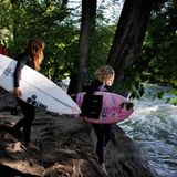 Maya Sauer und Annette Wilk gehen mit ihren Brettern zum Bach.