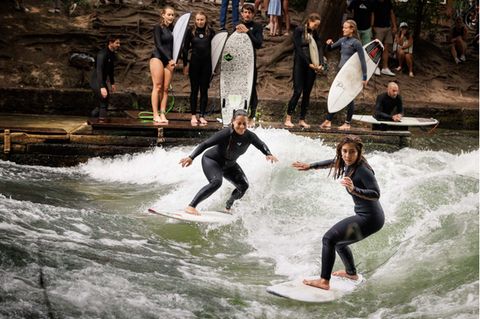 Mutter und Tochter surfen auf der Welle.