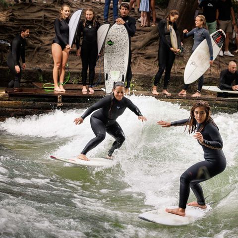 Mutter und Tochter surfen auf der Welle.