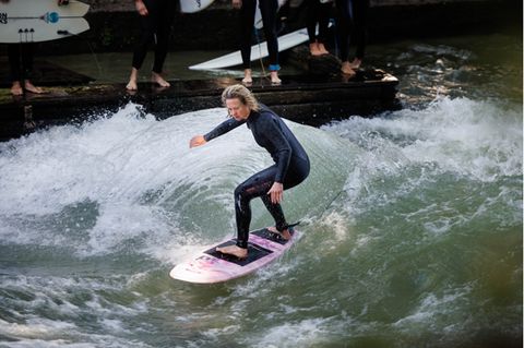 Annette Wilk surft auf der Eisbachwelle.