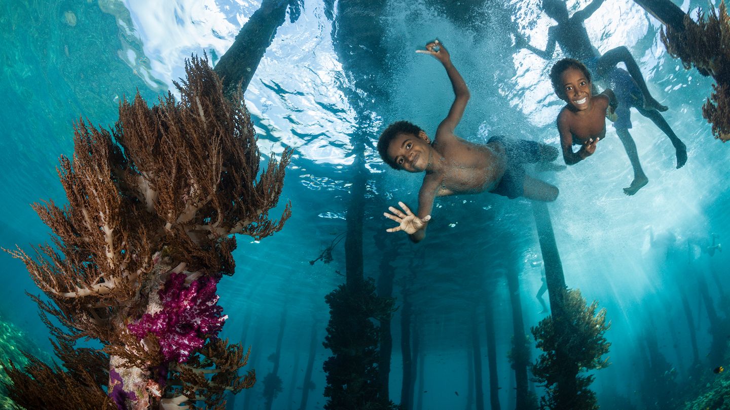 Kinder planschen am Steg  Fotografin: Daniela Dirscherl; München, Deutschland  Ort der Aufnahme: Raja Ampat, Indonesien  Kinder planschen am Steg, Raja Ampat, West Papua, Indonesien
