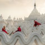 Pagoda Novice Monks  Fotograf: Chin Leong Teo; Singapur  Ort der Aufnahme: Myanmar  In Myanmar treten viele Kinder schon als kleine Jungen ins Mönchsleben ein. Sie verrichten Aufgaben in den Klöstern und lernen täglich die buddhistischen Schriften. Aber als Kinder, die sie sind, gönnen sie sich trotzdem ein wenig Spielzeit. Auf diesem Foto nimmt sich ein Mönchsnovize die Zeit, ein wenig zu rennen und zu springen, während seine Freunde sich zum Beten niederlassen