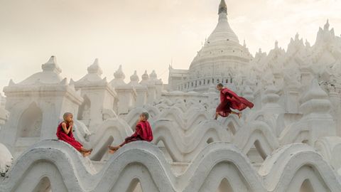 Pagoda Novice Monks  Fotograf: Chin Leong Teo; Singapur  Ort der Aufnahme: Myanmar  In Myanmar treten viele Kinder schon als kleine Jungen ins Mönchsleben ein. Sie verrichten Aufgaben in den Klöstern und lernen täglich die buddhistischen Schriften. Aber als Kinder, die sie sind, gönnen sie sich trotzdem ein wenig Spielzeit. Auf diesem Foto nimmt sich ein Mönchsnovize die Zeit, ein wenig zu rennen und zu springen, während seine Freunde sich zum Beten niederlassen