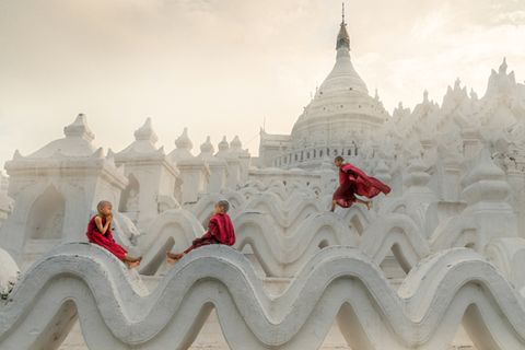 Pagoda Novice Monks  Fotograf: Chin Leong Teo; Singapur  Ort der Aufnahme: Myanmar  In Myanmar treten viele Kinder schon als kleine Jungen ins Mönchsleben ein. Sie verrichten Aufgaben in den Klöstern und lernen täglich die buddhistischen Schriften. Aber als Kinder, die sie sind, gönnen sie sich trotzdem ein wenig Spielzeit. Auf diesem Foto nimmt sich ein Mönchsnovize die Zeit, ein wenig zu rennen und zu springen, während seine Freunde sich zum Beten niederlassen