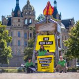 Aktivisten von Greenpeace stellten vor dem Schweriner Schloss einen symbolischen Bohrturm auf
