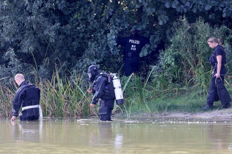 Vier Polizisten, darunter ein Taucher durchsuchen das Gebiet am See in Pragsdorf