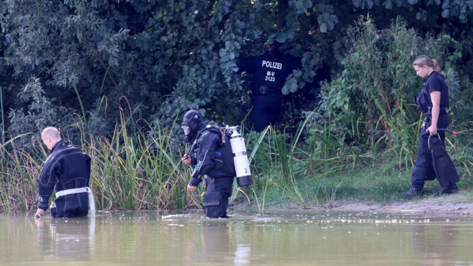 Vier Polizisten, darunter ein Taucher durchsuchen das Gebiet am See in Pragsdorf