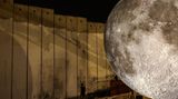 Aida Camp, Palästina. Über dem Flüchtlingscamp in Palästina neben Israels umstrittenem Grenzzaun hat der britische Künstler Luke Jerram sein "Museum of the Moon" errichtet. Mit dem Kunstwerk im Lager will Jerram Hoffnung vermitteln und Solidarität mit den Palästinensern zeigen.