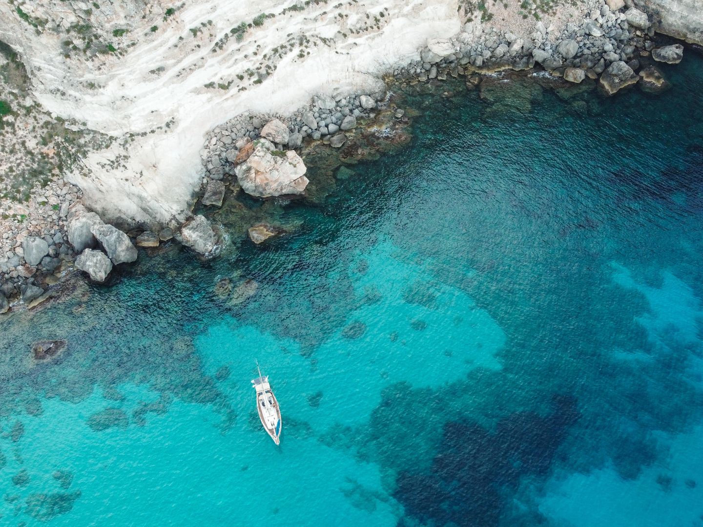 Blick von oben auf türkisfarbenes Wasser  in einem Naturschutzgebiet vor Guadeloupe